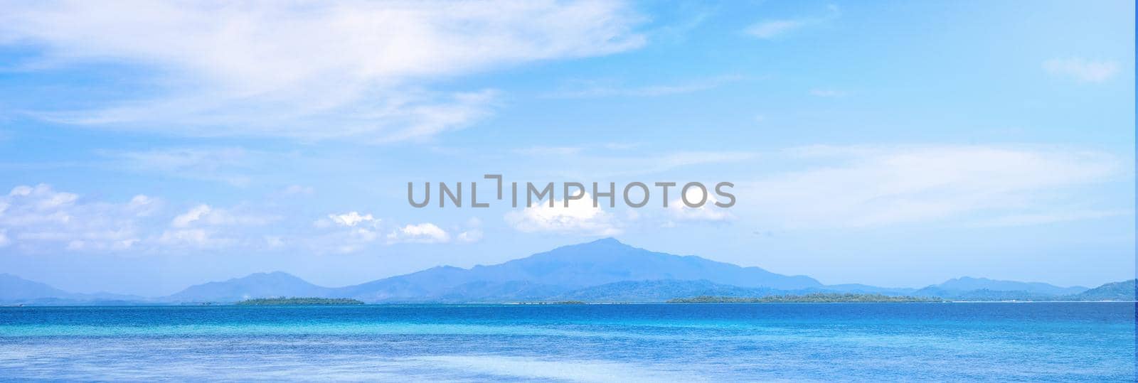 Beautiful ocean scene view isolated with light blue sky background, concept of vacation and sea travel, copy space