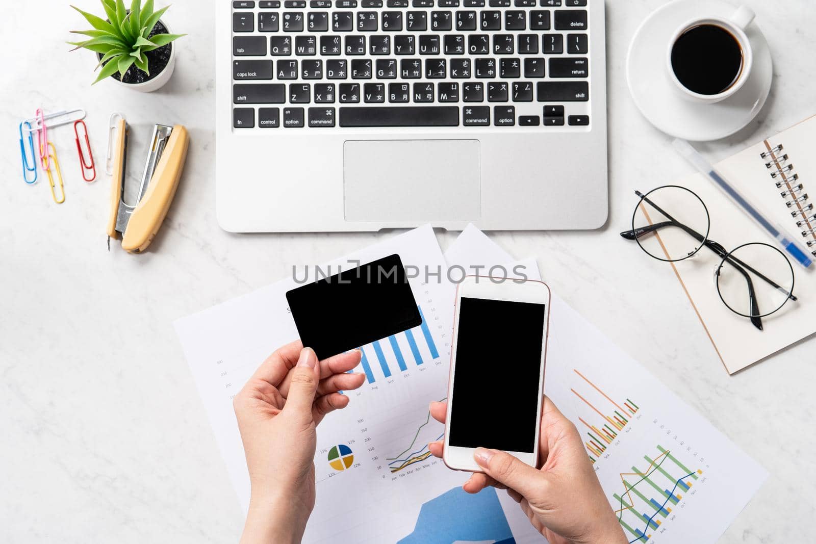 Online bill payment concept, a woman using mock up credit card and mobile cell phone on office desk isolated on beautiful fashion marble background, copy space, topview, flatlay, closeup