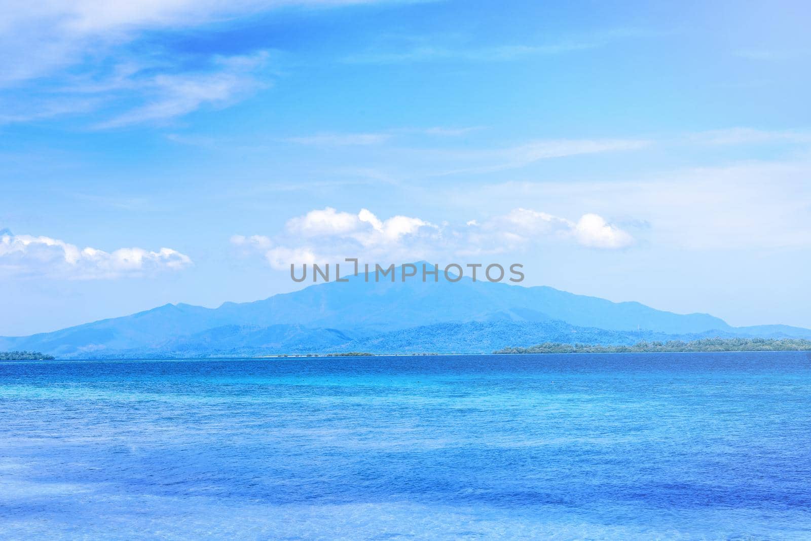 Beautiful ocean scene view isolated with light blue sky background, concept of vacation and sea travel, copy space