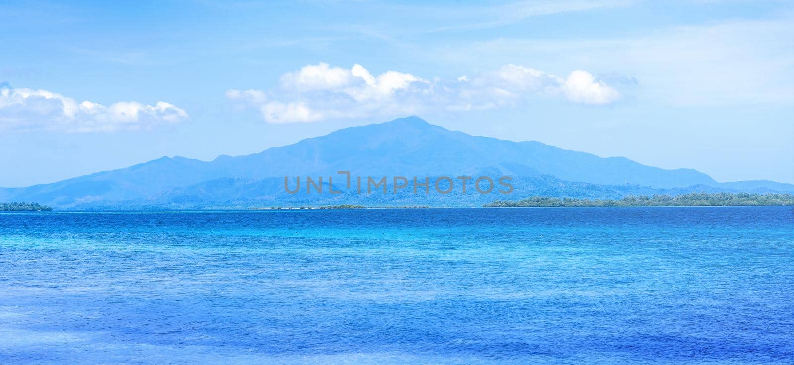Beautiful ocean scene view isolated with light blue sky background, concept of vacation and sea travel, copy space
