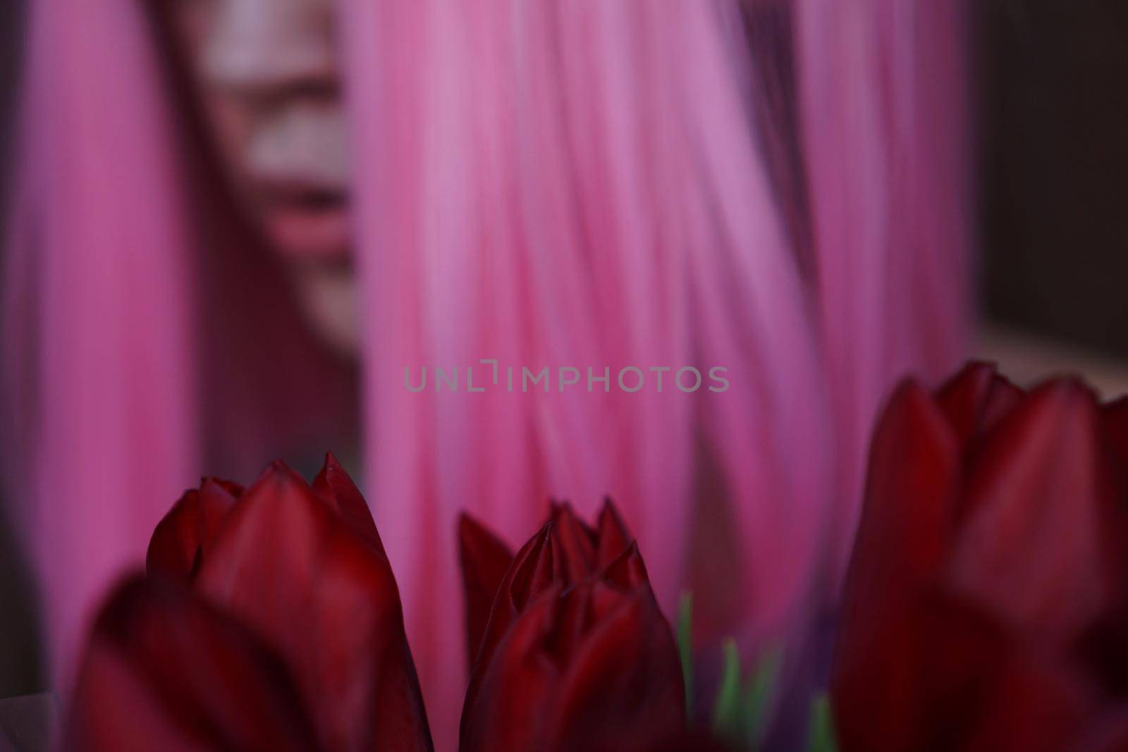 Girl with pink hair with flowers close to face. Out of focus, blurred background by natali_brill