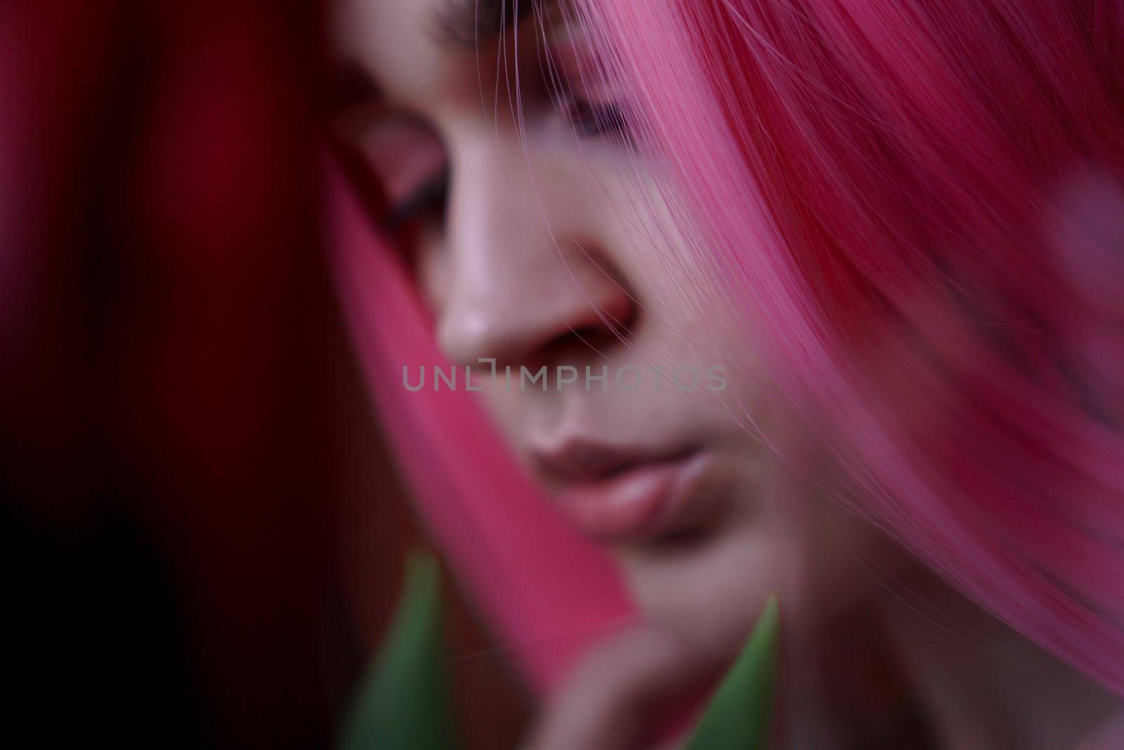 Girl with pink hair with flowers close to face. Out of focus, blurred background by natali_brill