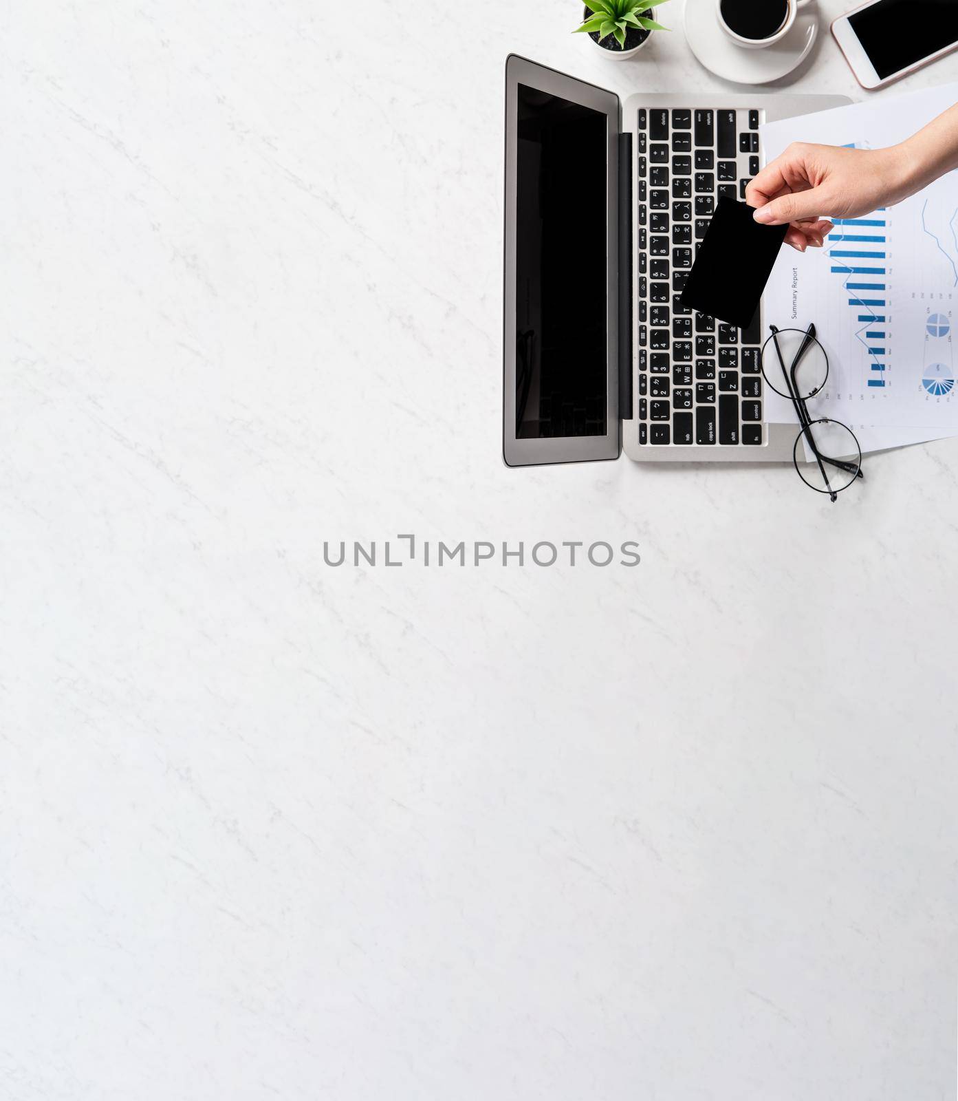 Concept of a woman is doing a online purchase, mock up card and cellphone on office desk isolated on beautiful fashion marble background, copy space, top view, flat lay, closeup