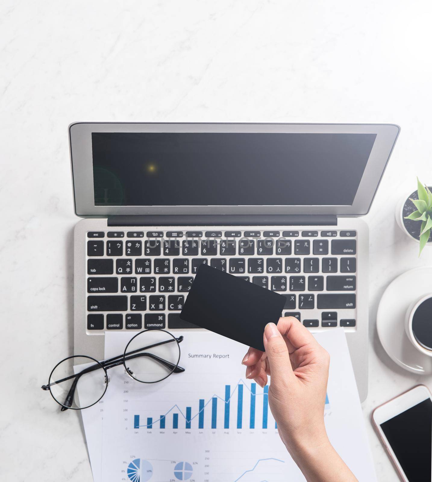 Concept of a woman is doing a online purchase, mock up card and cellphone on office desk isolated on beautiful fashion marble background, copy space, top view, flat lay, closeup