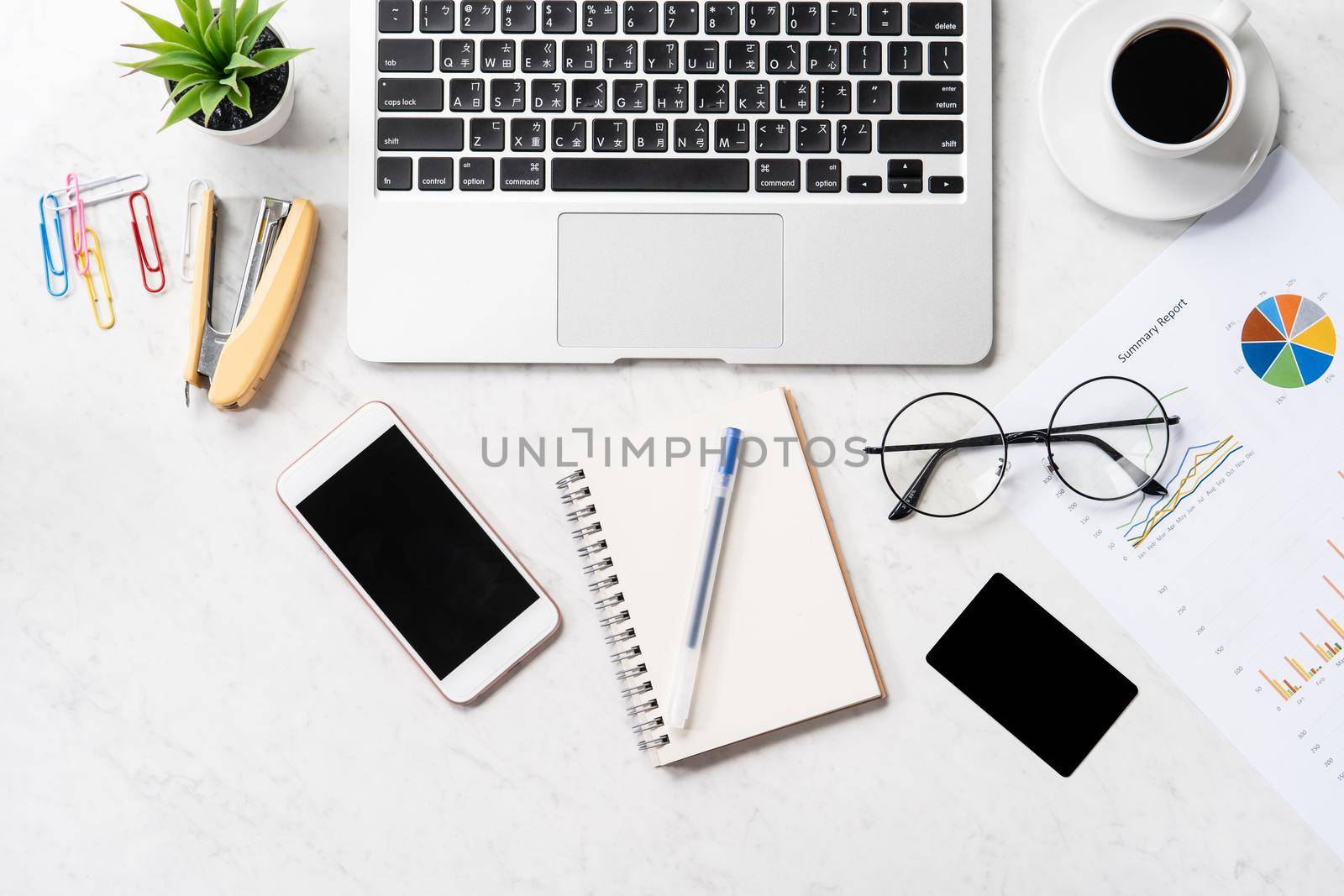 Stylized clean marble office working desk with smartphone, laptop, glasses and coffee, workspace design, mock up, top view, flat lay, copy space, closeup