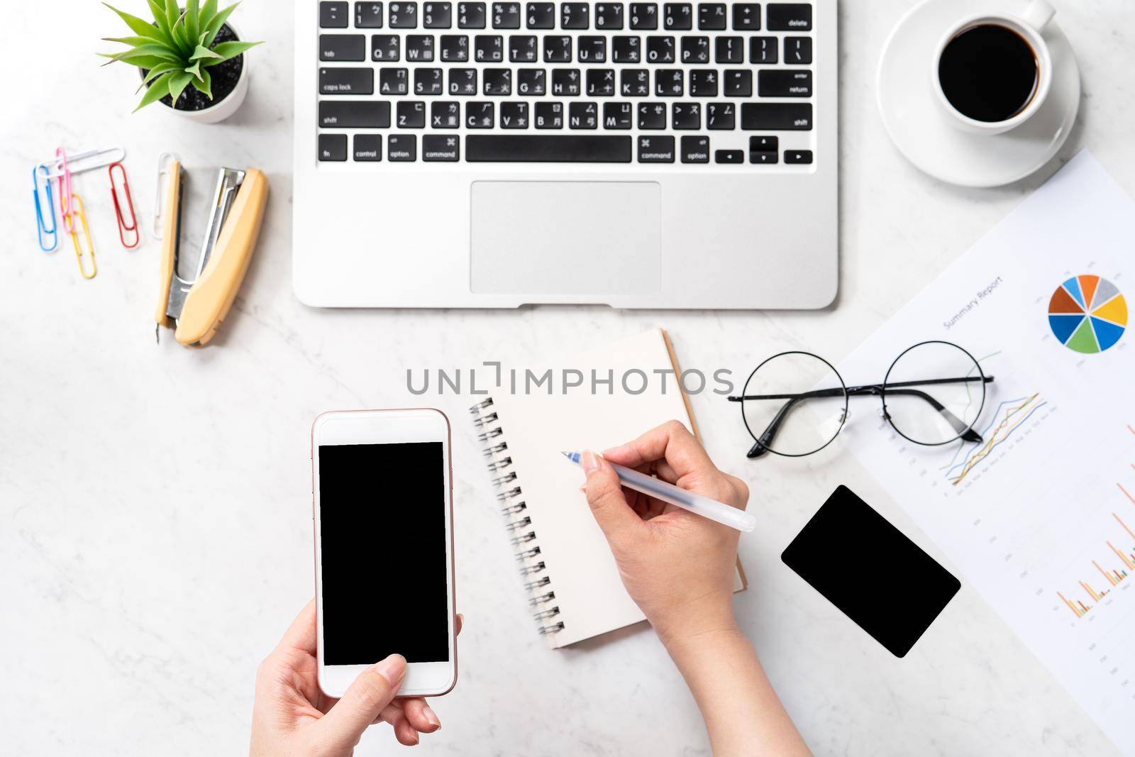Concept of a woman is doing a accounting, mock up card and cellphone on office desk isolated on beautiful fashion marble background, copy space, top view, flat lay, closeup
