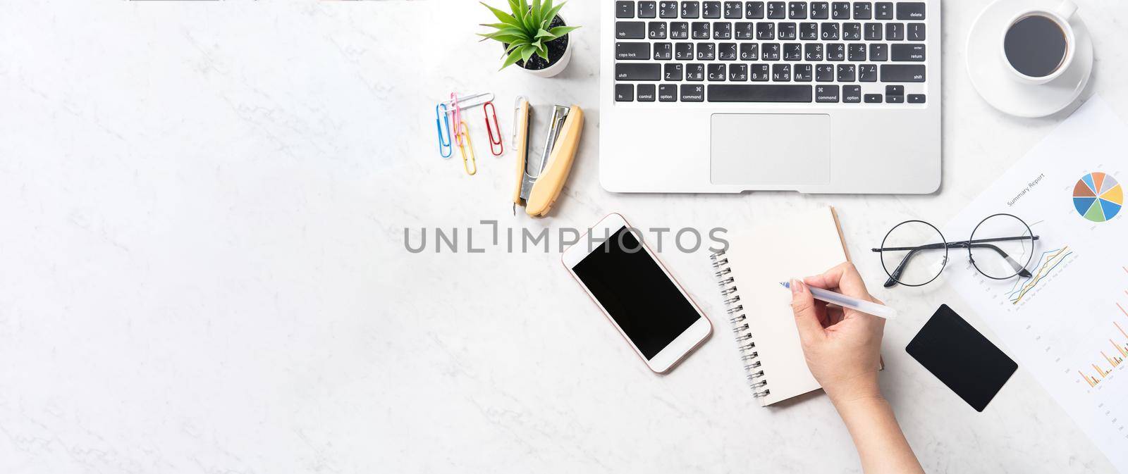 Concept of a woman is doing a accounting, mock up card and cellphone on office desk isolated on beautiful fashion marble background, copy space, top view, flat lay, closeup