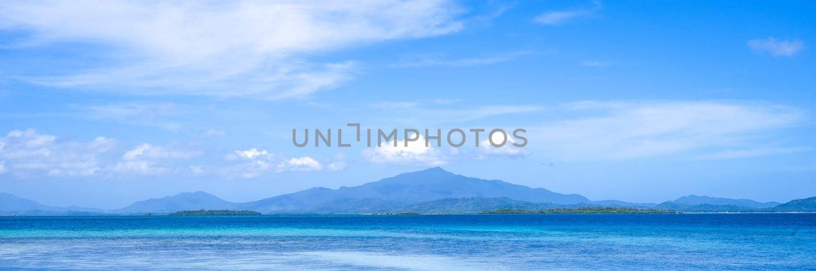 Beautiful ocean scene view isolated with light blue sky background, concept of vacation and sea travel, copy space