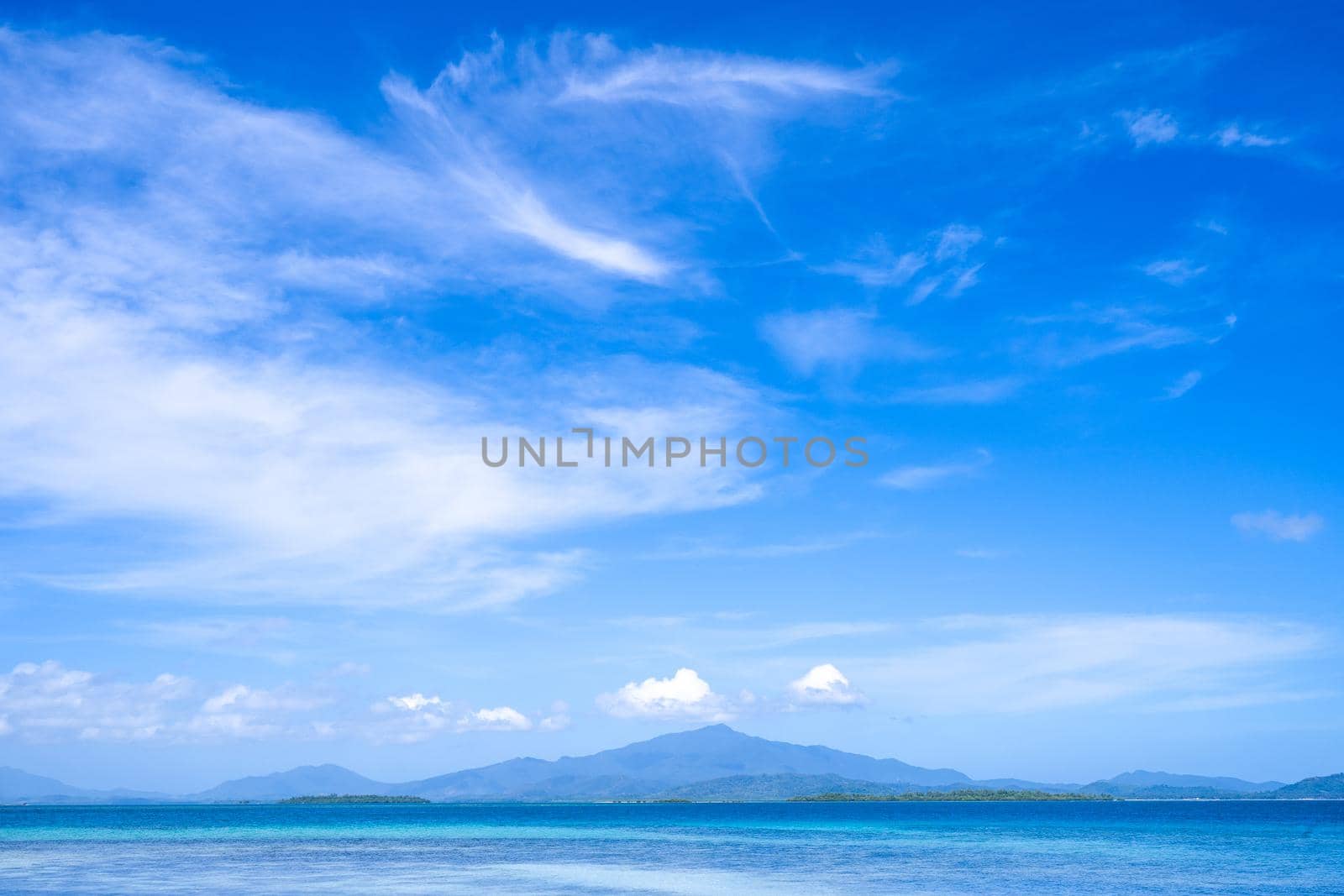 Beautiful ocean scene view isolated with light blue sky background, concept of vacation and sea travel, copy space