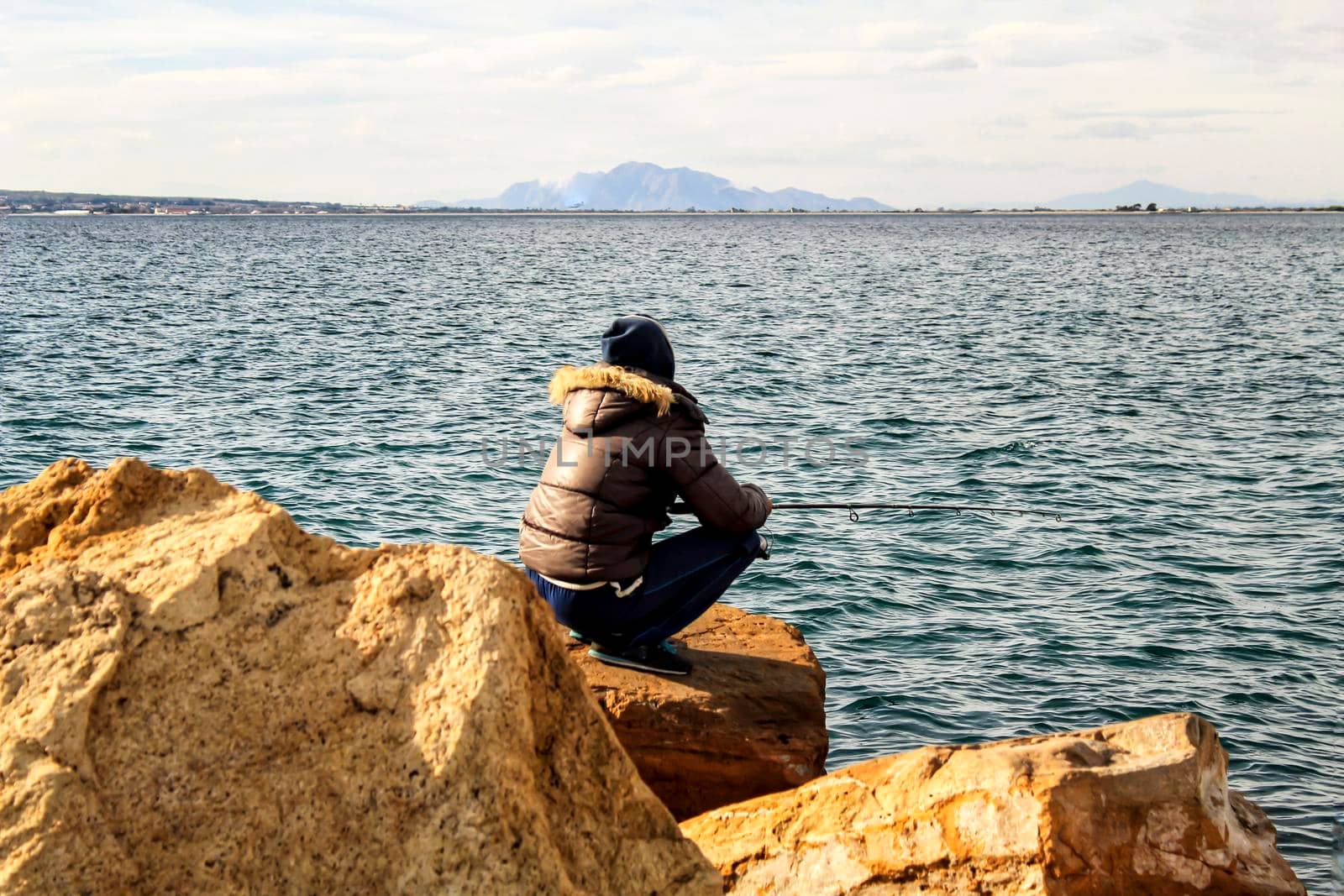 Man Fishing and relaxing in a sunny day in Santa Pola, Alicante, Spain