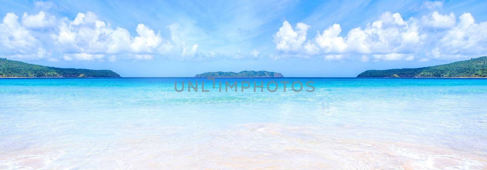 Beautiful amazing gold colored sandy beach with soft waves isolated with sunny blue sky. Concept of tropical calm tourism idea, copy space, close up
