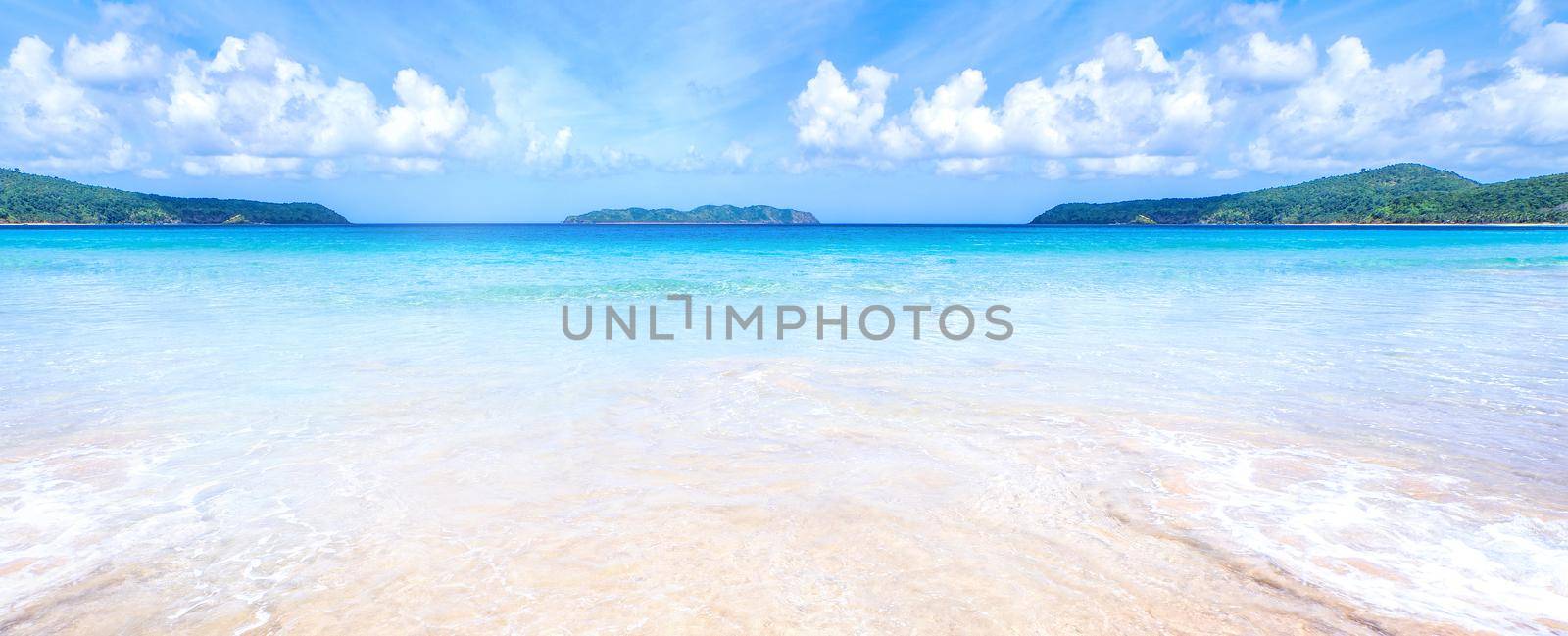 Beautiful amazing gold colored sandy beach with soft waves isolated with sunny blue sky. Concept of tropical calm tourism idea, copy space, close up