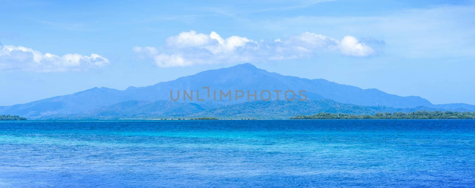Beautiful ocean scene view isolated with light blue sky background, concept of vacation and sea travel, copy space