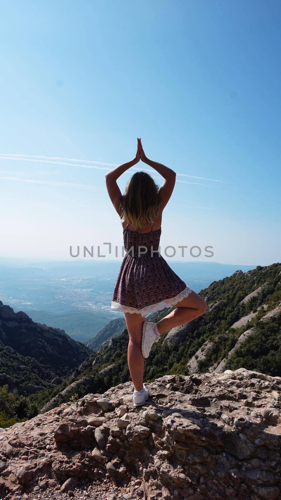 Young woman standing in a yoga pose - Montserrat Mountains by natali_brill