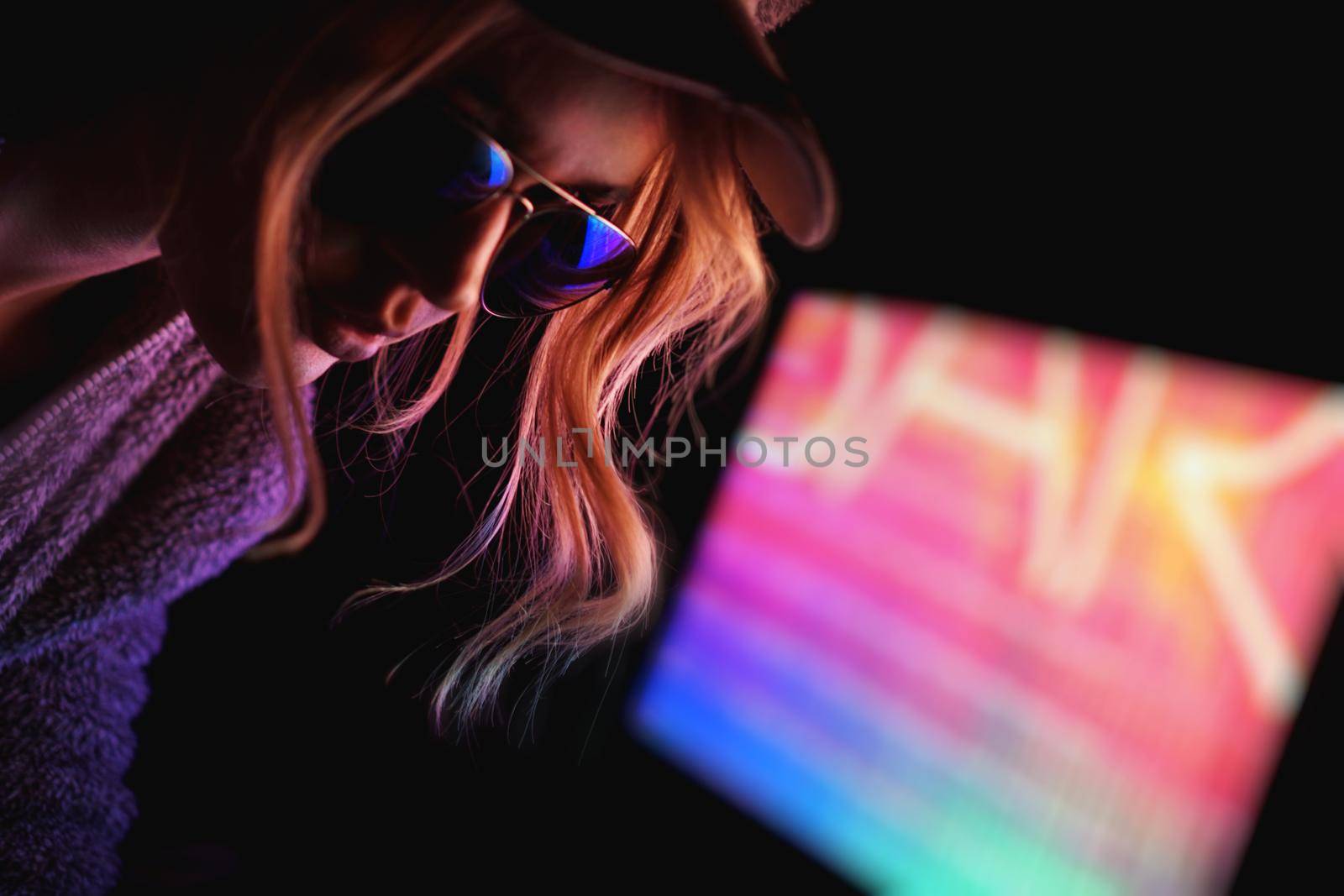 Portrait of the Beautiful Young Pro Gamer Girl. Attractive Girl with Glasses by Neon Lights.
