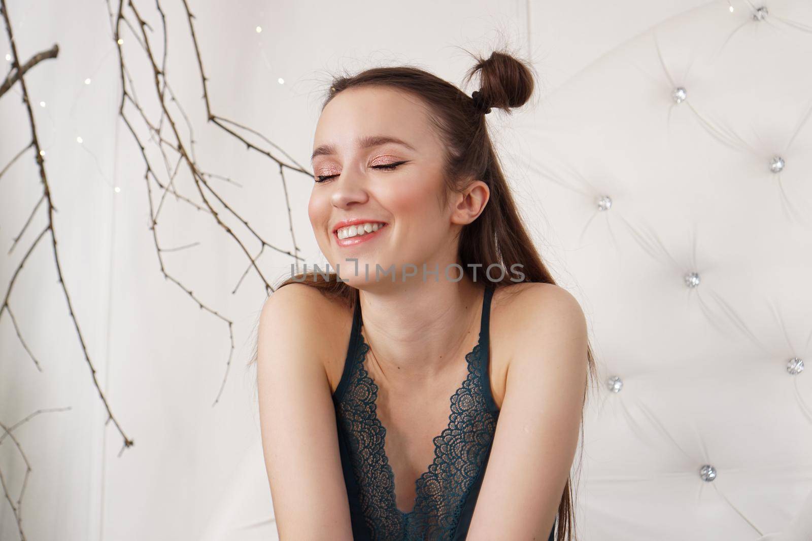 Portrait of a beautiful girl in a peignoir. Beautiful sexy lady on the bed in her bedroom. Fashion model indoors. Female underwear. Happy morning