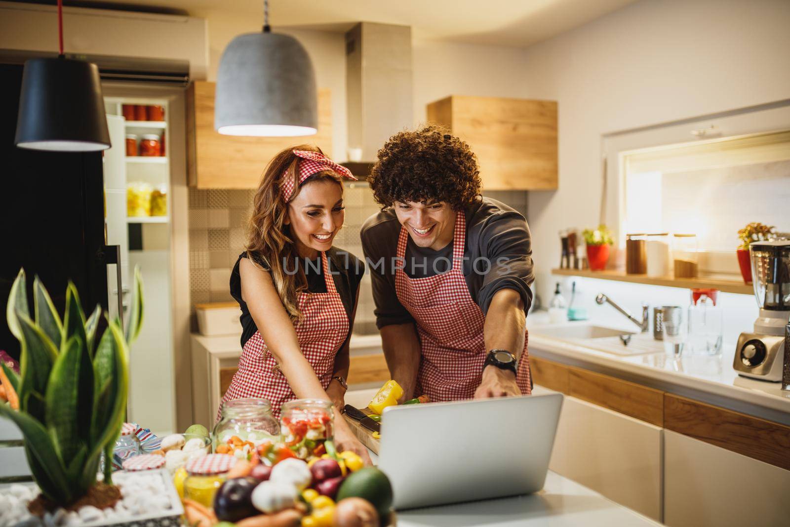 A beautiful smiling couple trying out a new recipe in the kitchen together.