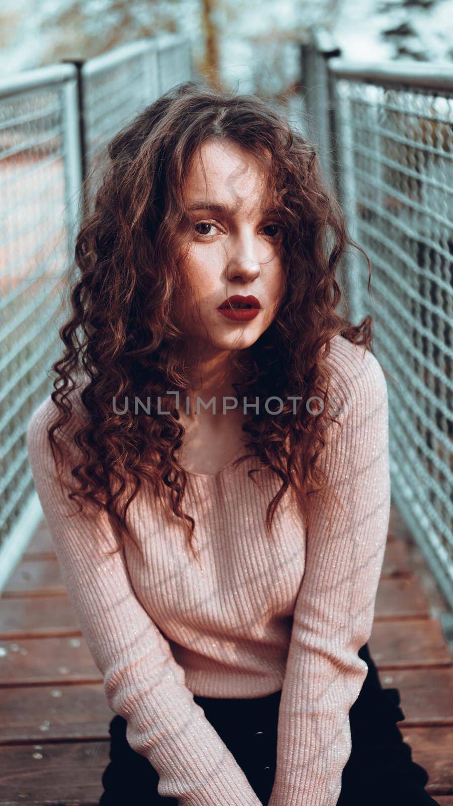 Fashion portrait of trendy young woman sitting near the netting rabitz by natali_brill