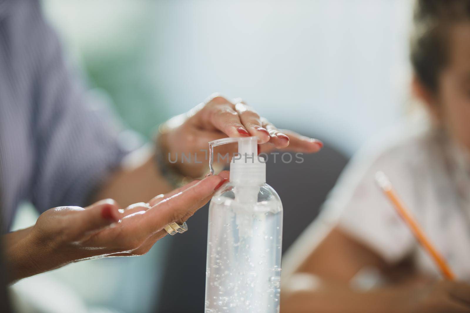 Cropped shot of an unrecognizable woman using antiseptic gel to disinfect her hands at her home office during corona virus pandemic.