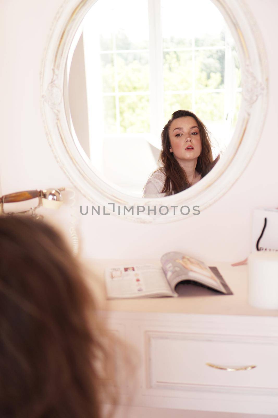 Beautiful happy woman in her room near her dressing table posing before party - pink dressing room