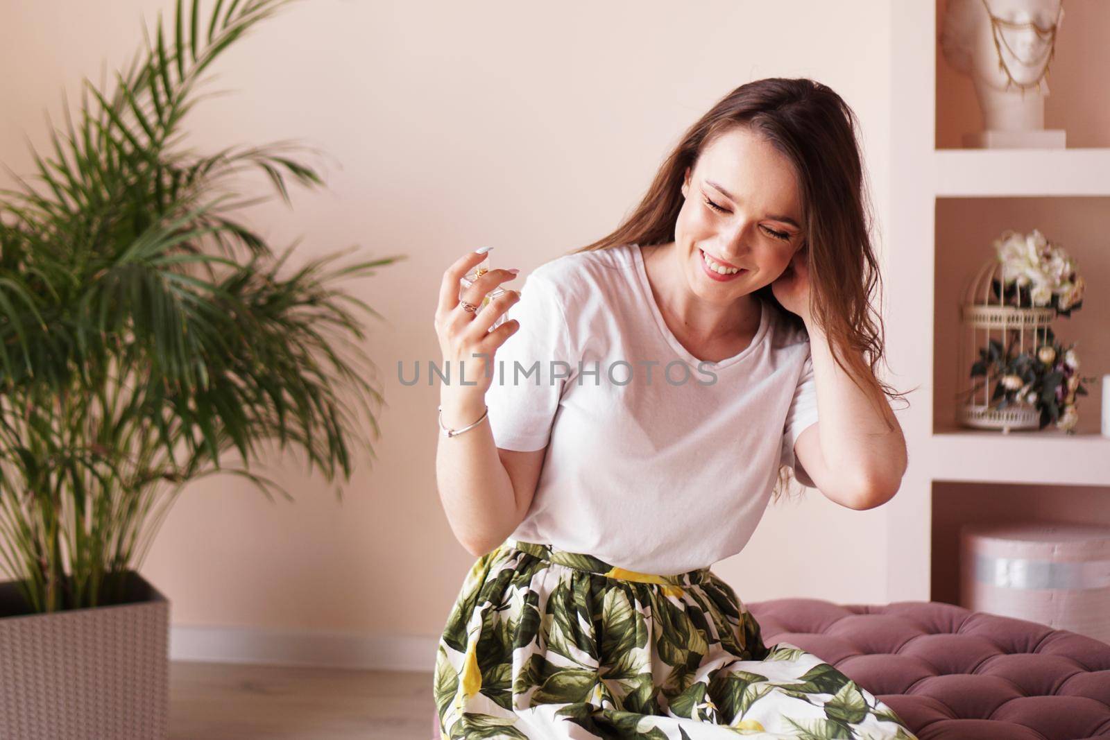 Beautiful young woman with bottle of perfume at home - dressing room by natali_brill