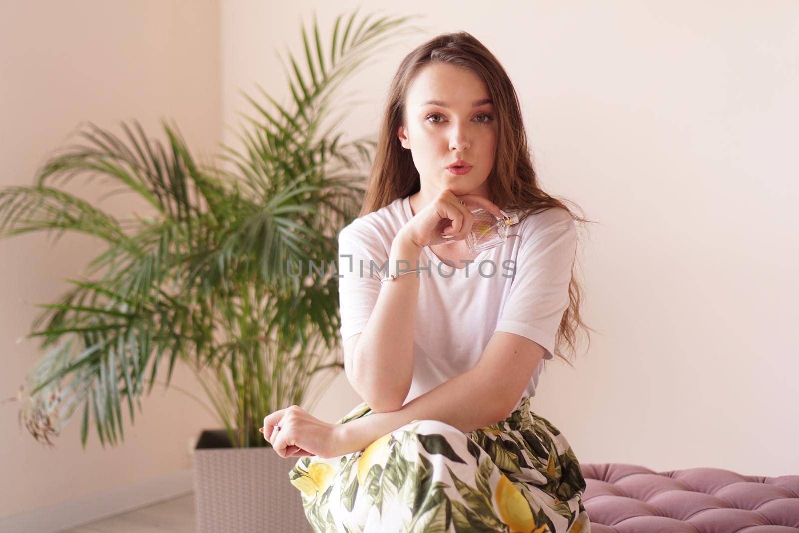 Beautiful young woman with bottle of perfume at home - dressing room by natali_brill