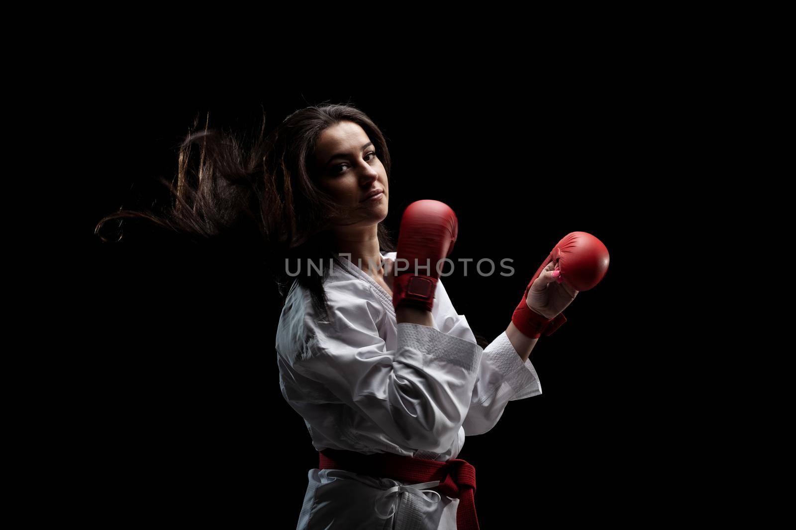 karate girl posing in kimono and red gloves against black background by kokimk