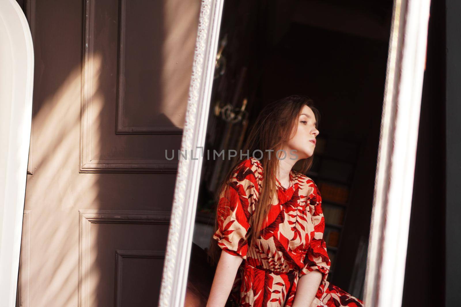 Portrait of woman and her reflection in the mirror in brown retro style room