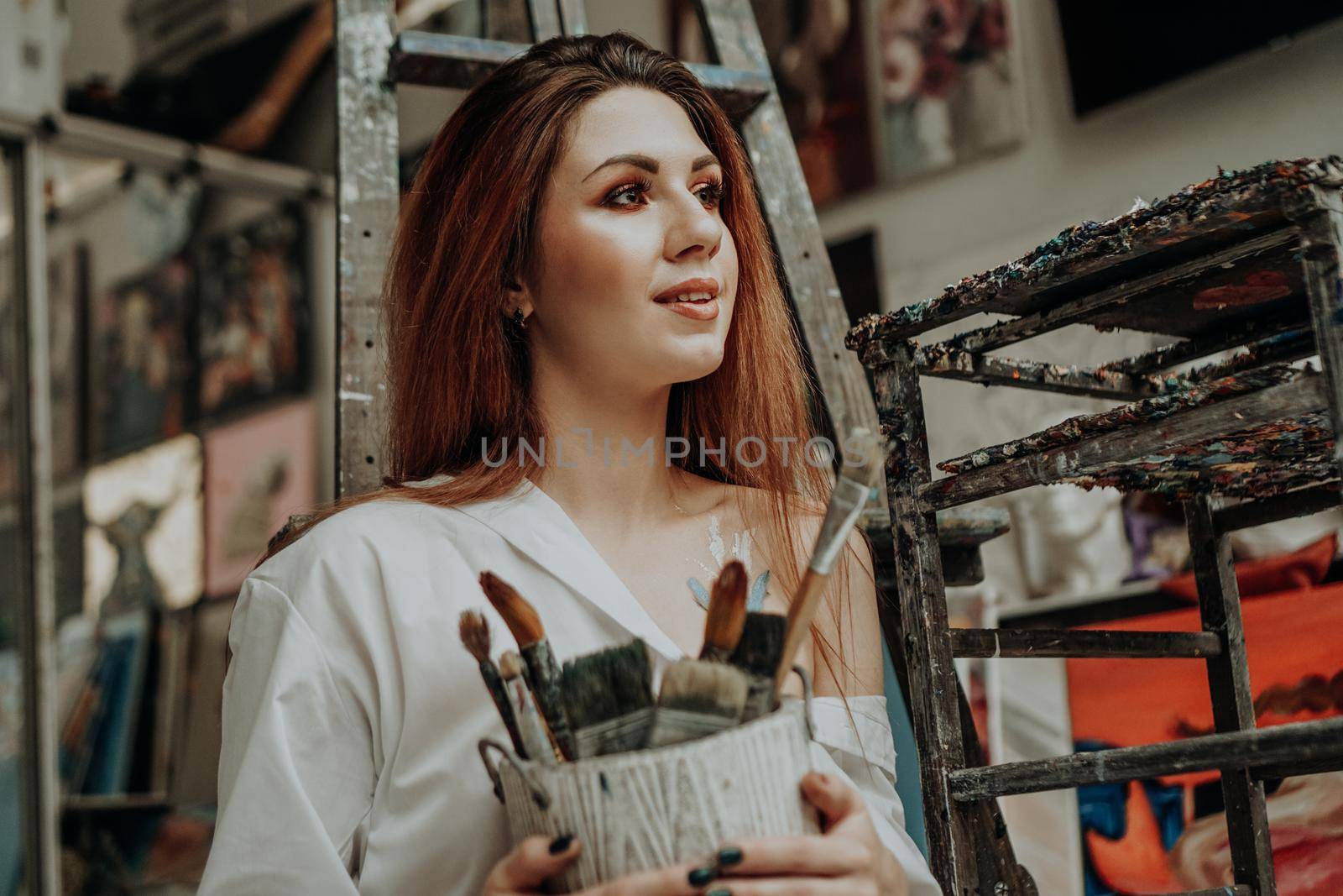 Female artist hand holding paintbrush at art workshop