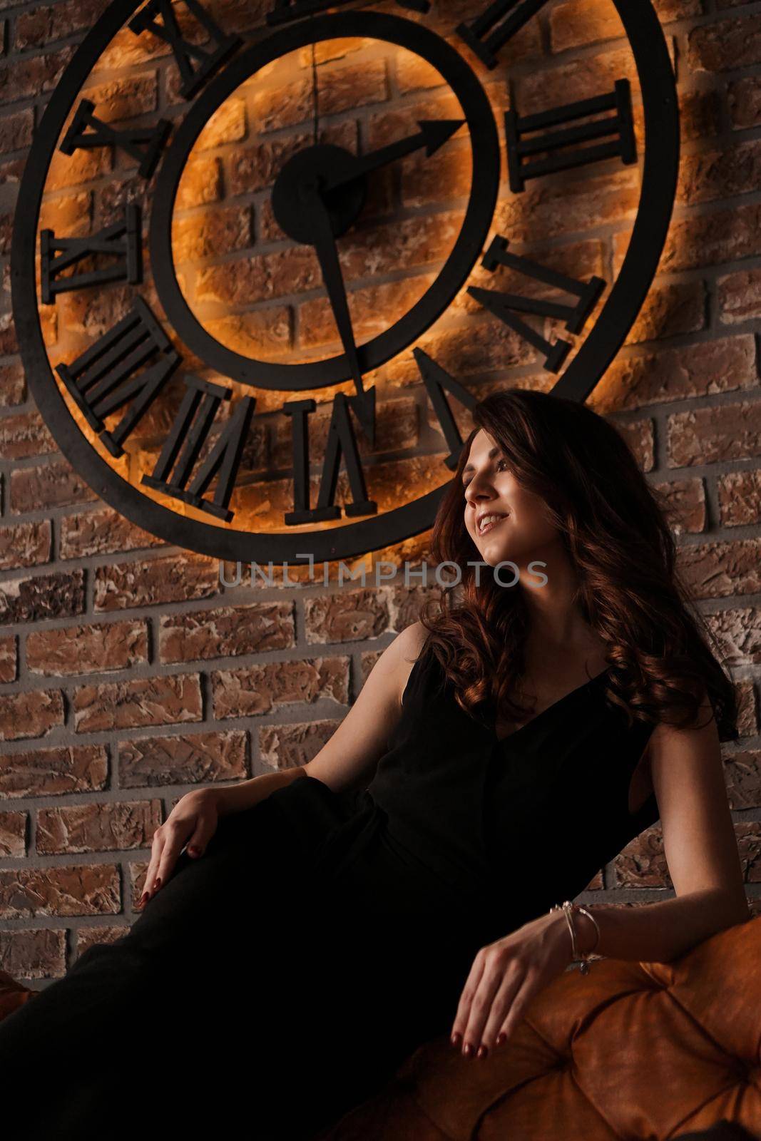 Young attractive woman under the clock, on brick wall background by natali_brill