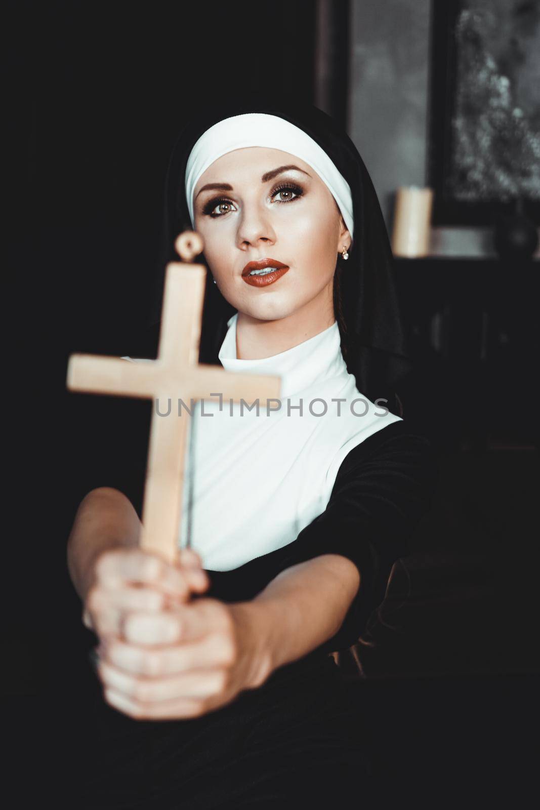 Nun holding a cross. The concept of religion. Young beautiful nun expels the devil