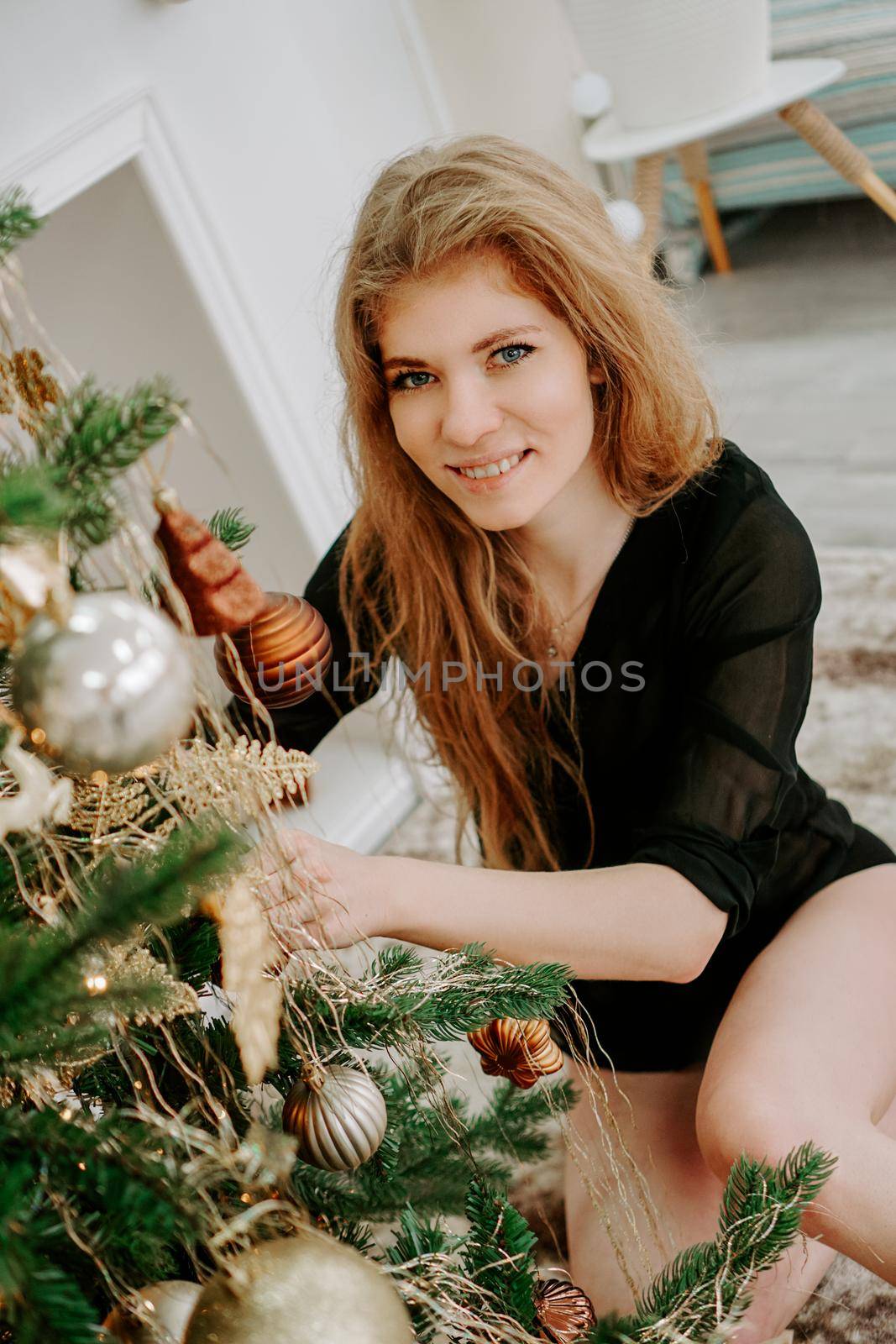 Beautiful young woman decorating a Christmas tree - soft colors preset