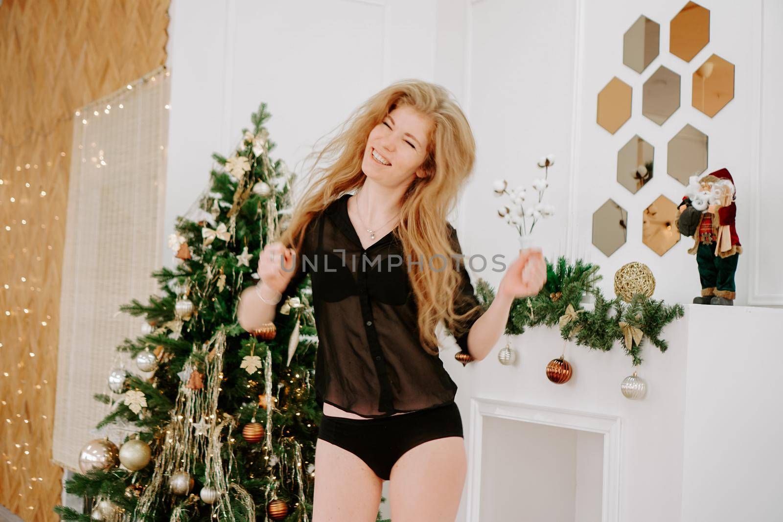 Charming happy girl inspired with christmas music while dancing at home