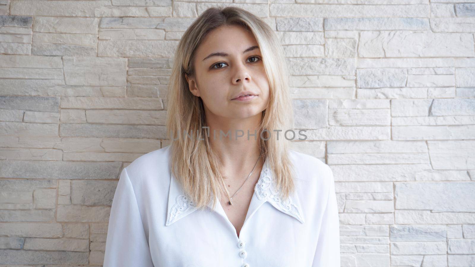 Portrait of attractive young european businesswoman on brick wall background. Leadership and leader concept