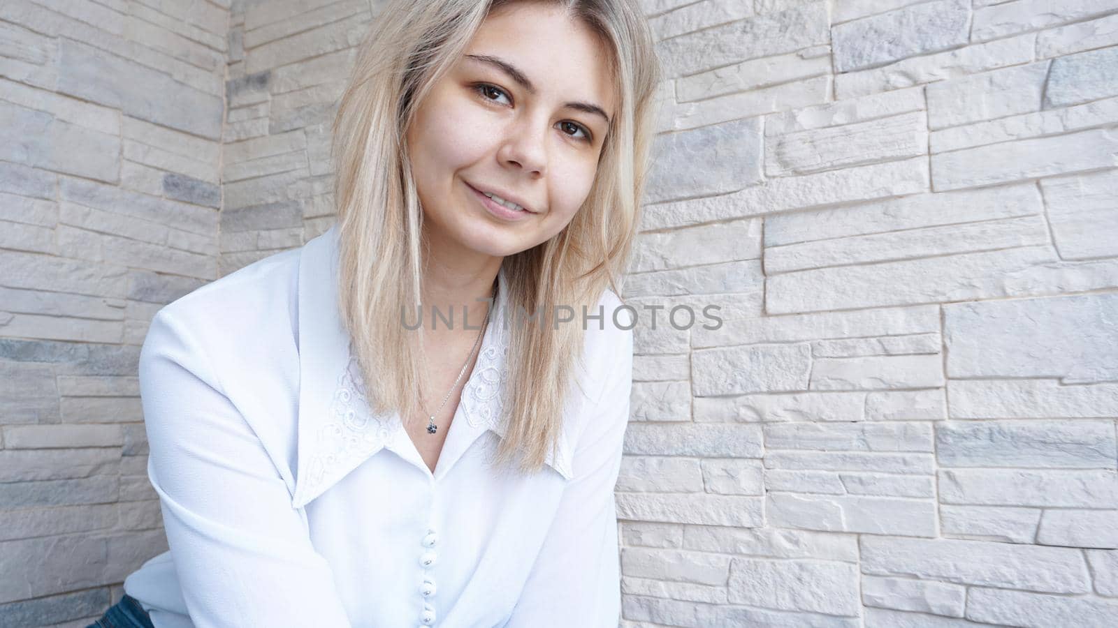 Portrait of attractive young european businesswoman on brick wall background. Success concept