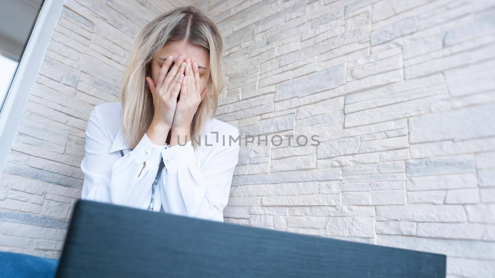 Woman looks at her laptop with a pained worried expression. Female employee is stressed out of work, touching aching head, reading email, solving a problem.