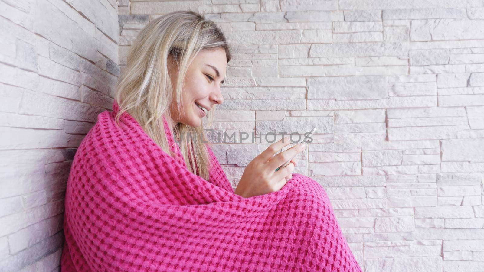 Pretty girl sitting on the window sill with smartphone in hands. by natali_brill