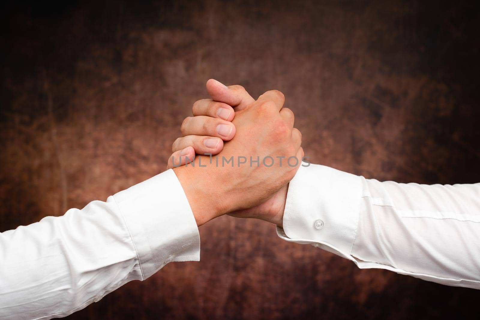 Corporate Businessmen Handshake Indoors.Two People Professionally Well Dressed Gesturing Togetherness.Working Colleague Partners Sign Deal In Agreement To Contract by nialowwa