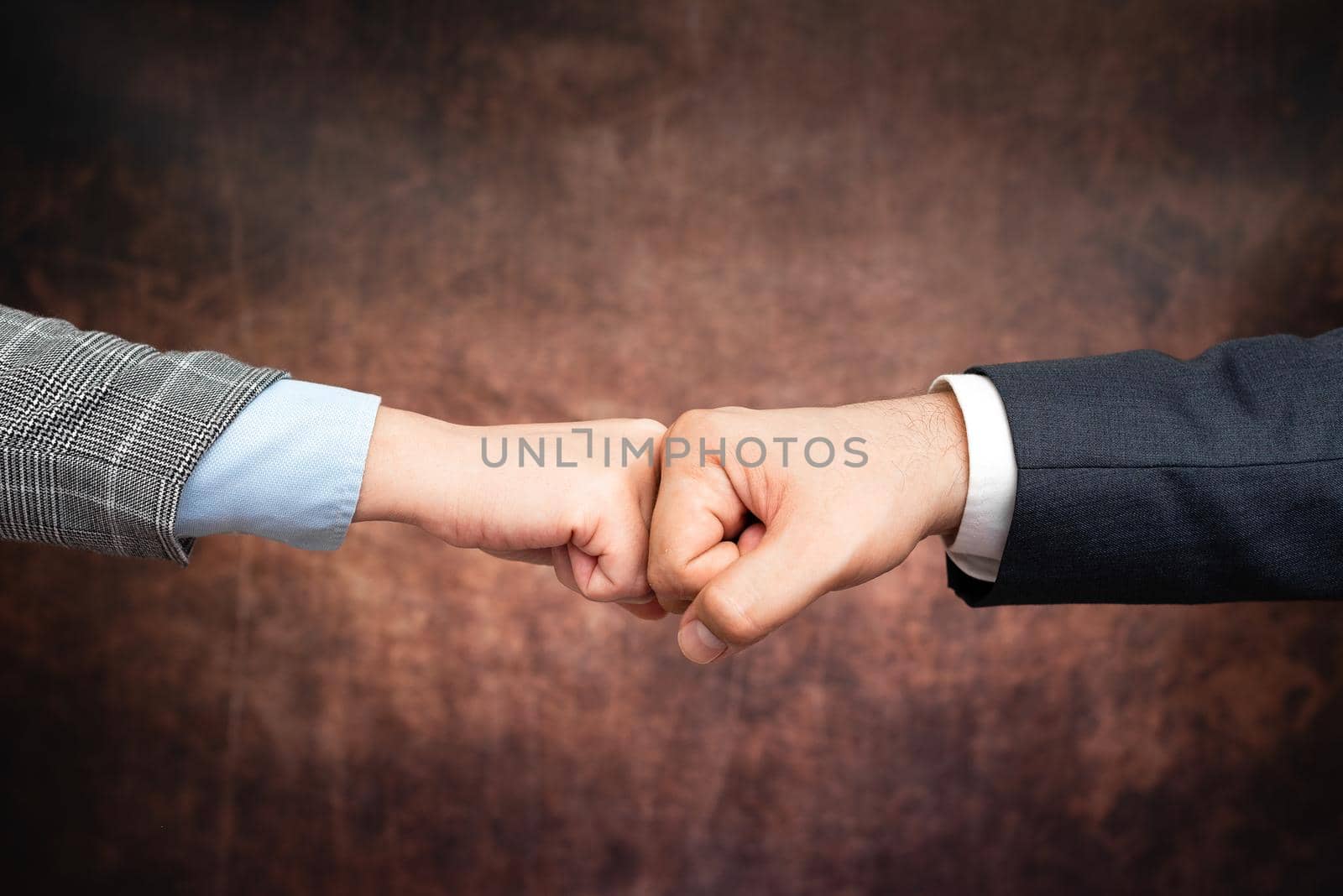 Corporate Businessmen Handshake Indoors.Two People Professionally Well Dressed Gesturing Togetherness.Working Colleague Partners Sign Deal In Agreement To Contract by nialowwa