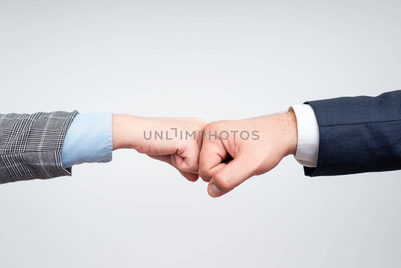 Corporate Businessmen Handshake Indoors.Two People Professionally Well Dressed Gesturing Togetherness.Working Colleague Partners Sign Deal In Agreement To Contract by nialowwa