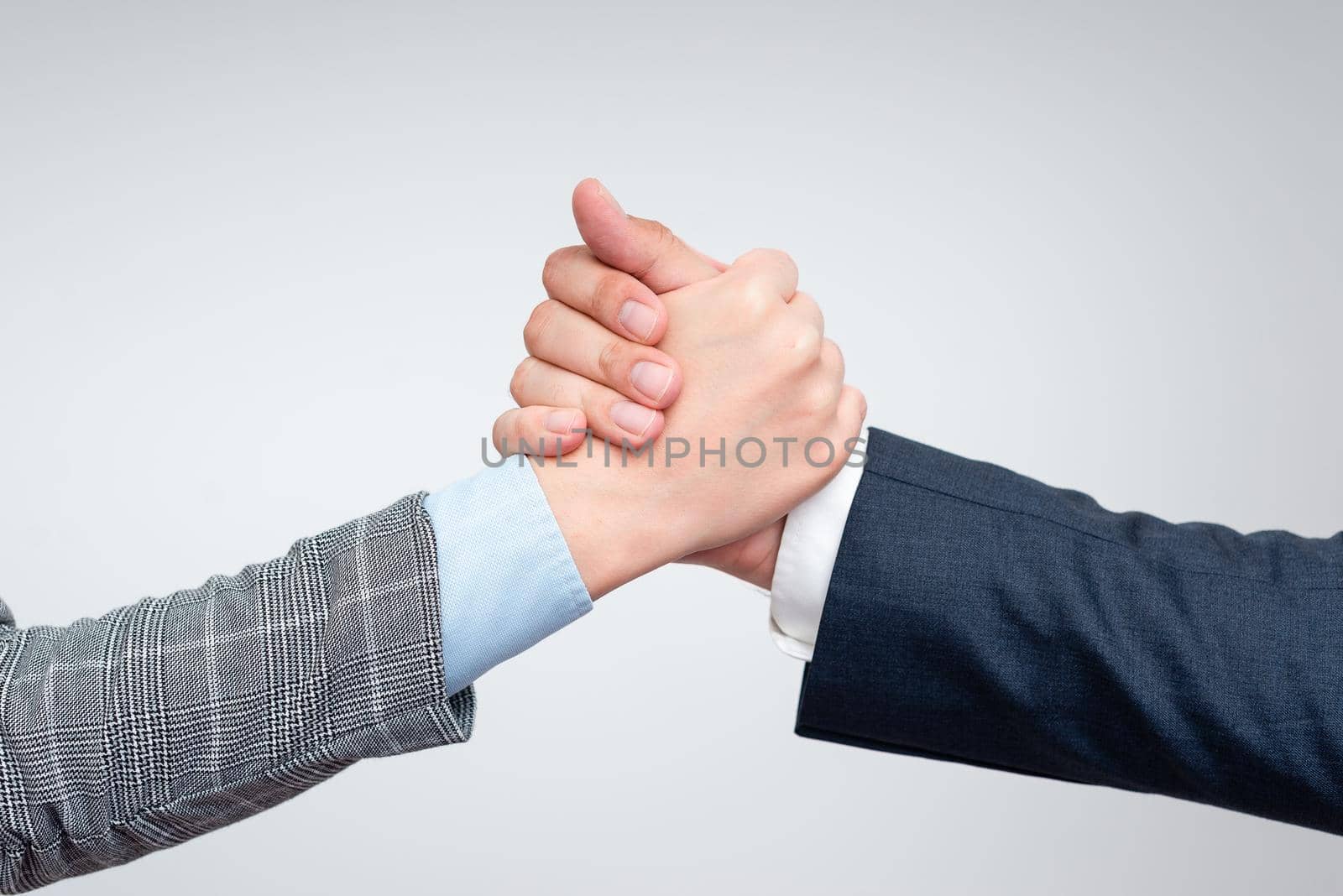 Corporate Businessmen Handshake Indoors.Two People Professionally Well Dressed Gesturing Togetherness.Working Colleague Partners Sign Deal In Agreement To Contract by nialowwa