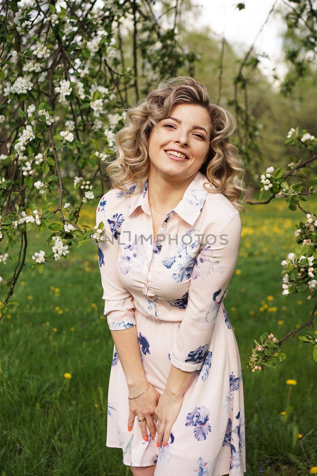 Beautiful young woman in apple garden in spring sunny day - happy moments