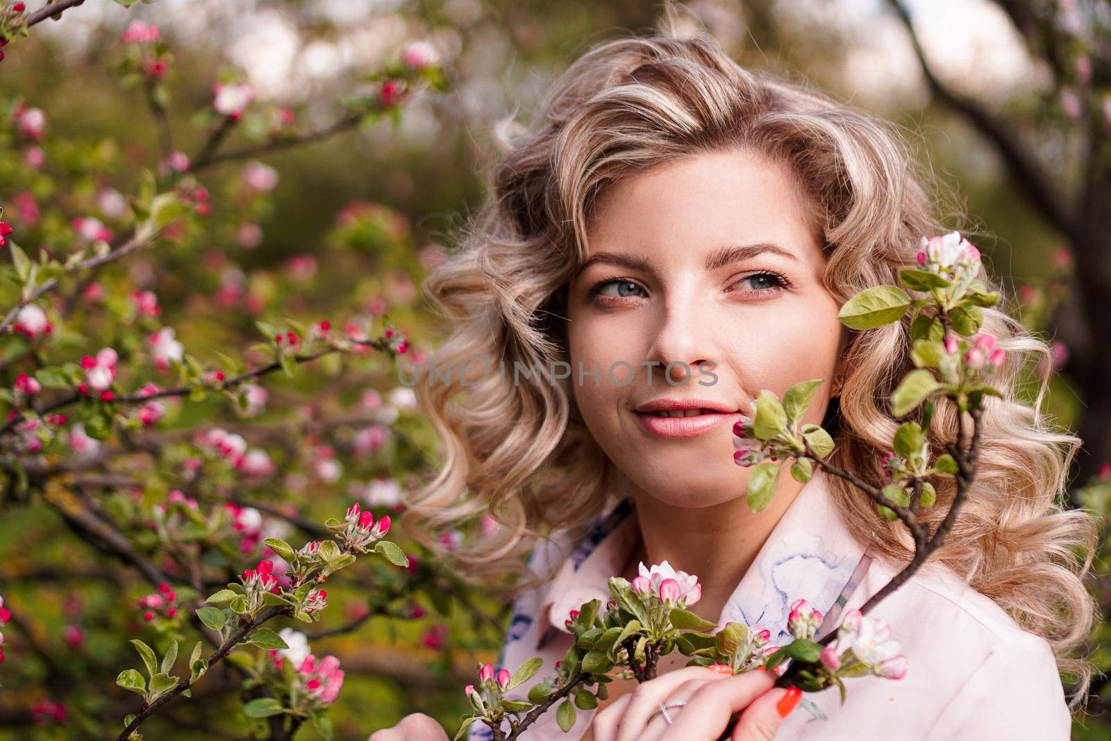 Romantic young woman in the spring garden among apple blossom. by natali_brill