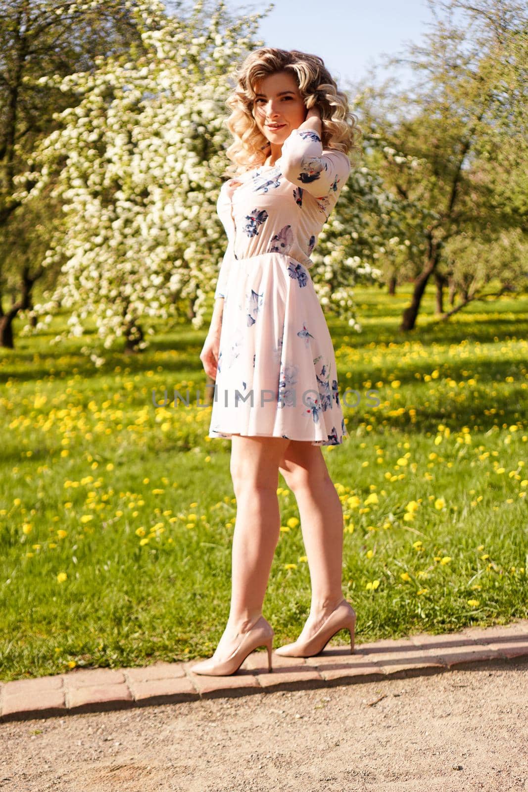 Beautiful young girl in park in the spring. Portrait in full height. vertical by natali_brill