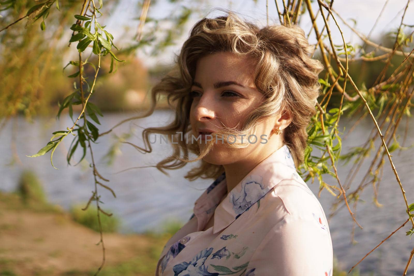 Portrait of woman in profile resting on the nature near the river. Sunny simmer day
