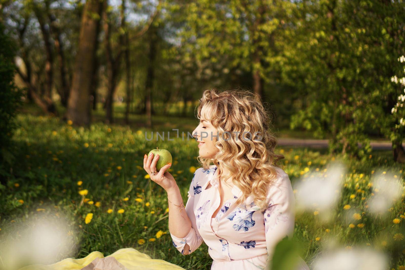 Woman with apple at a picnic in summer garden by natali_brill