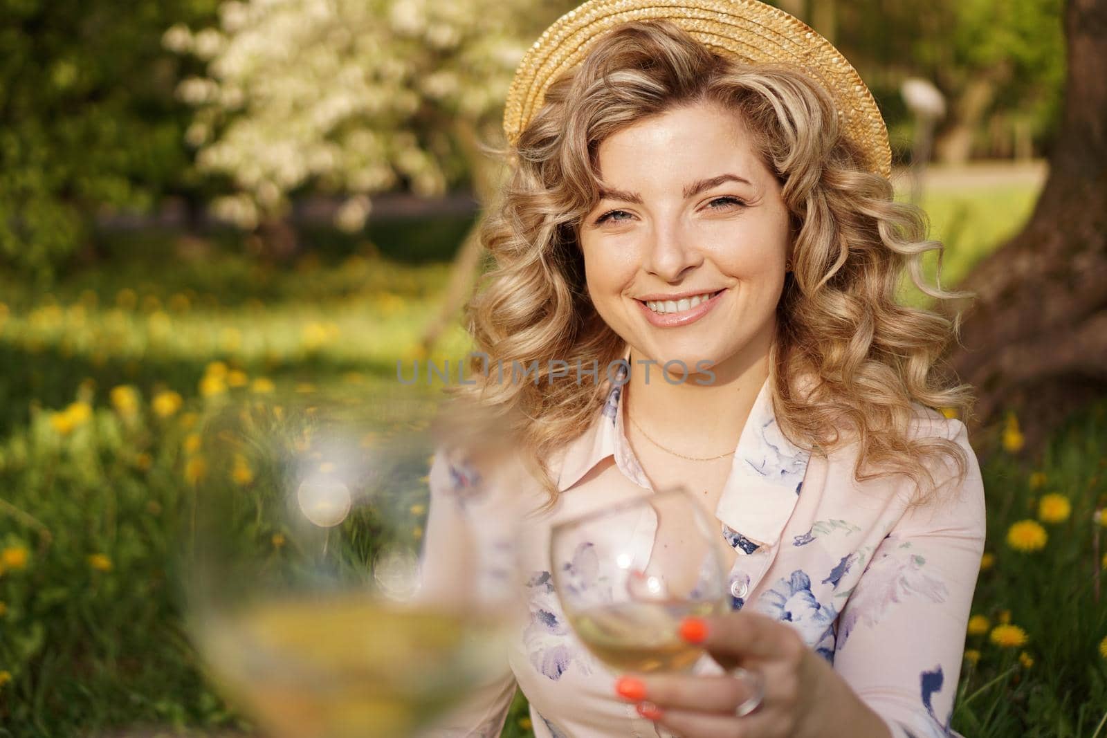 Women clinking glasses with tasty wine on light background by natali_brill