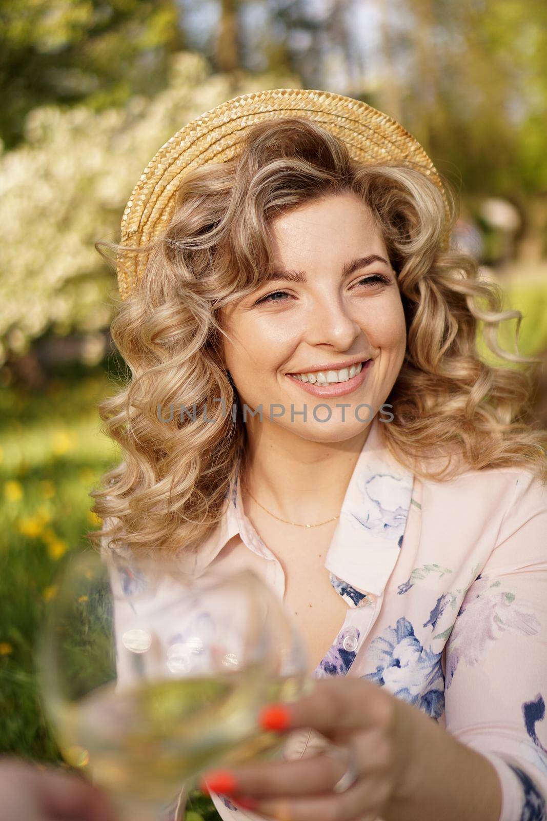 Women clinking glasses with tasty wine on light background by natali_brill