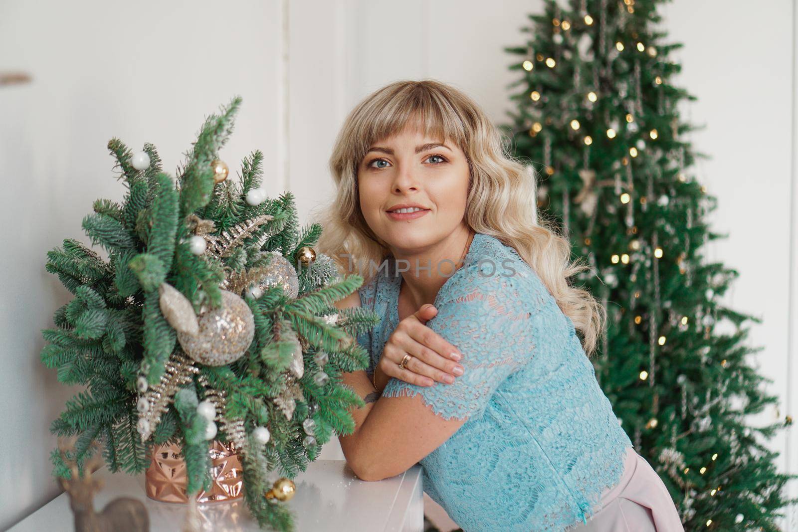 Charming Girl with Beautiful Make-up on Face in gold and white interior. Christmas Holidays, Merry Celebration with the Family