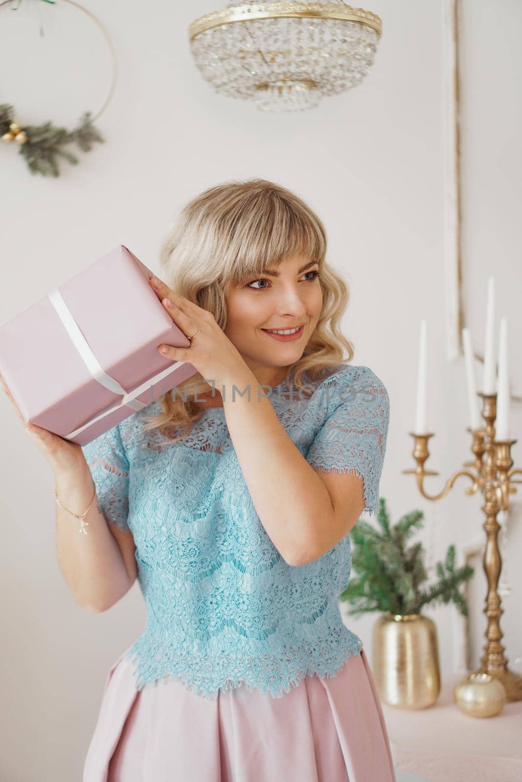 Lovely young woman with elegant style sitting indoor with pink Christmas present by natali_brill